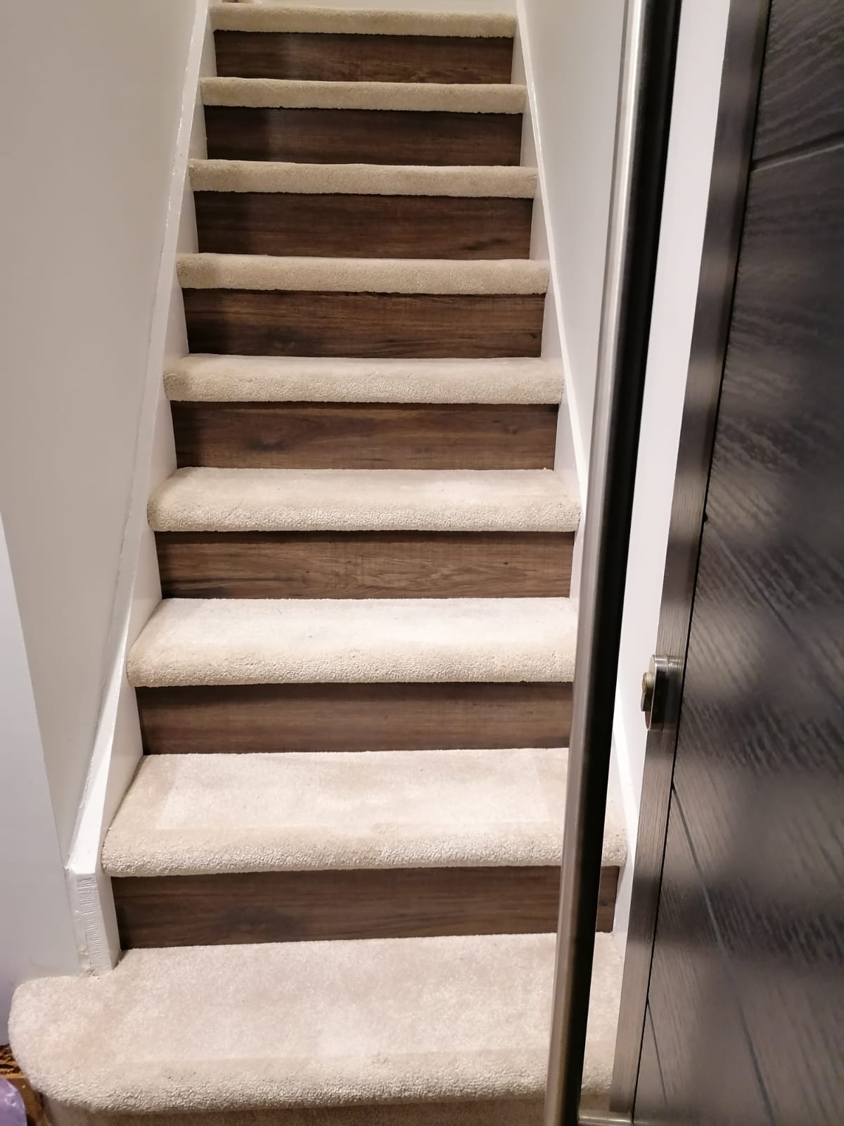 A set of stairs with carpeted steps in a house.