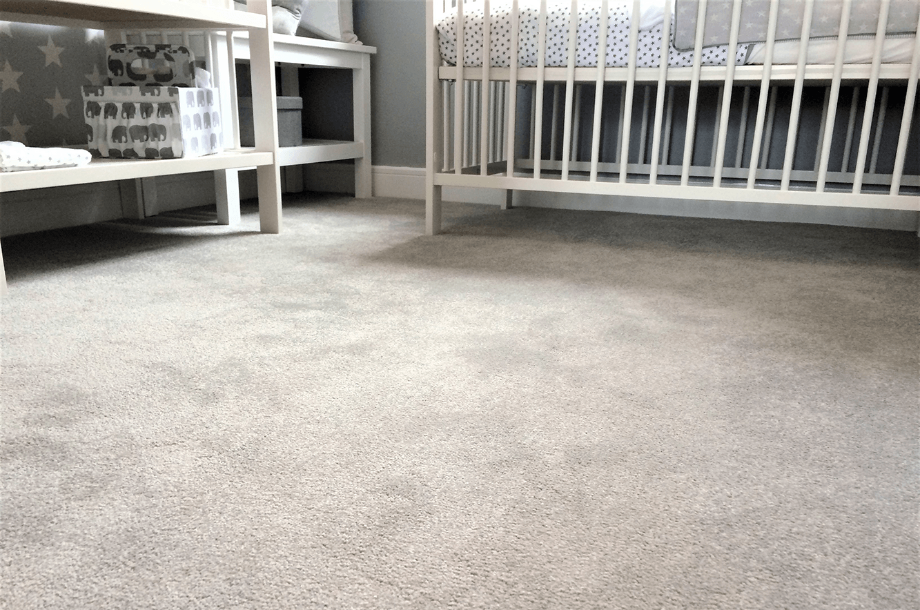 A baby crib is sitting next to a table in a room.