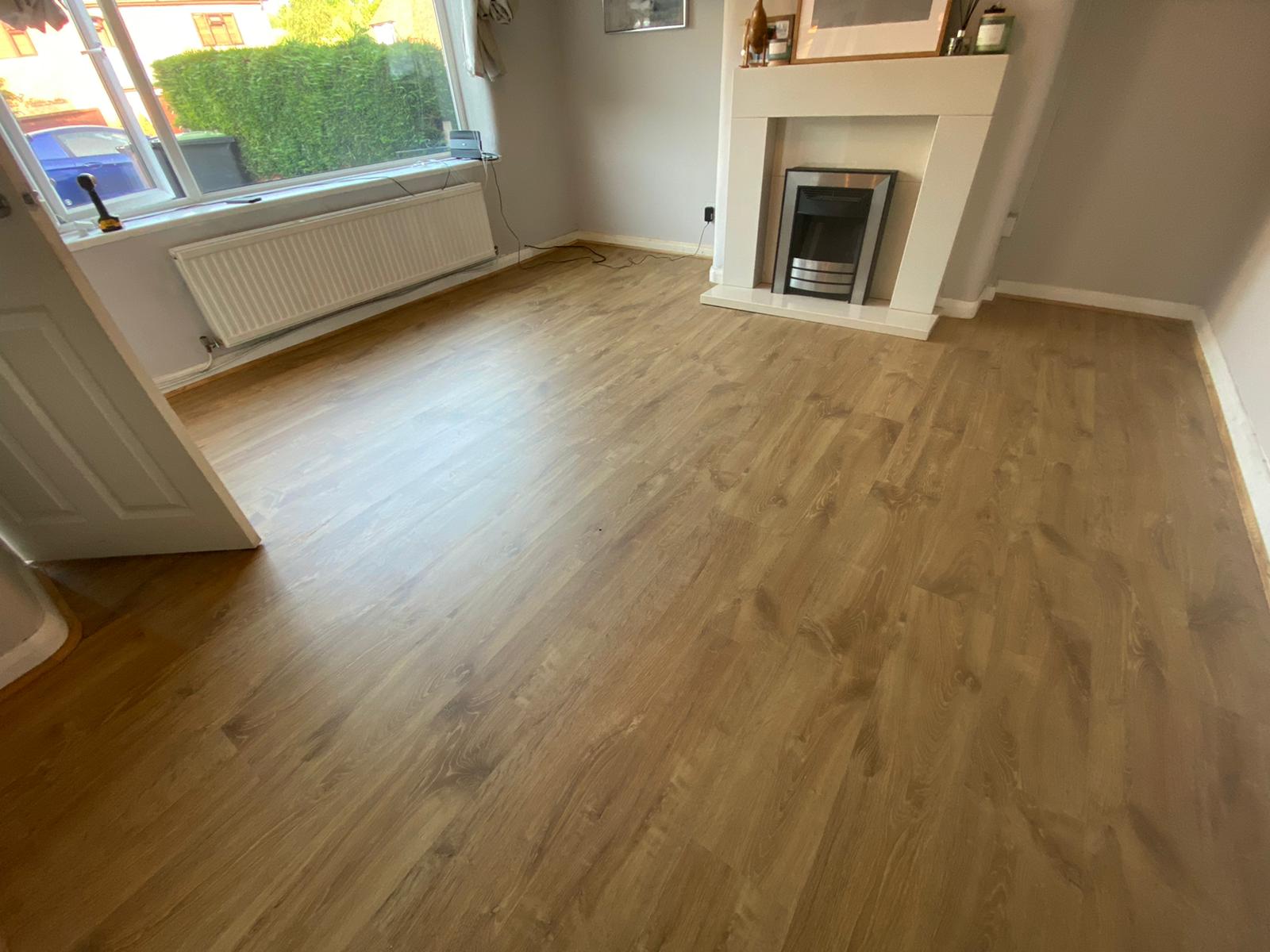 A living room with a wooden floor and a fireplace.