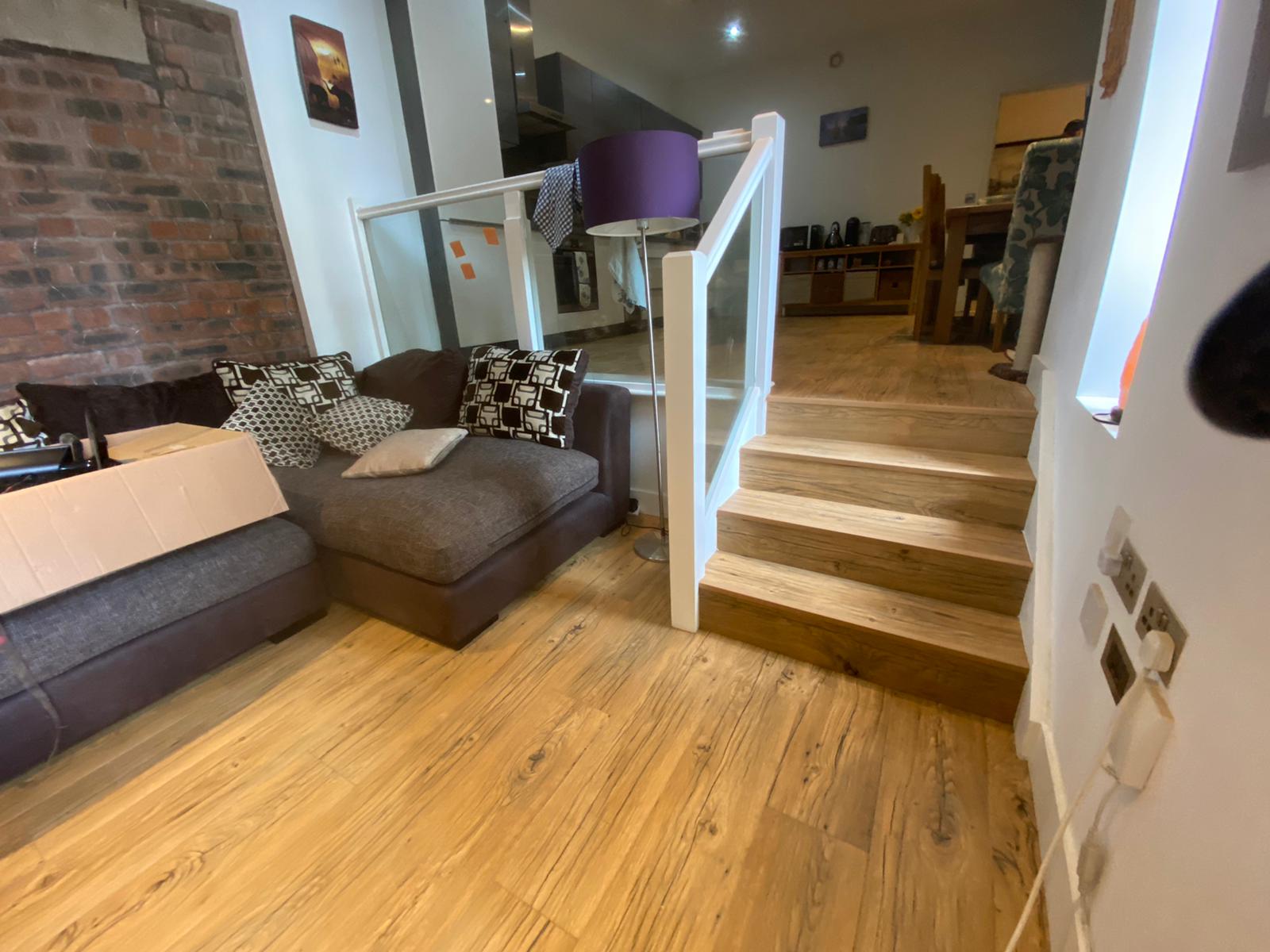 A living room with a couch and stairs leading up to the second floor.