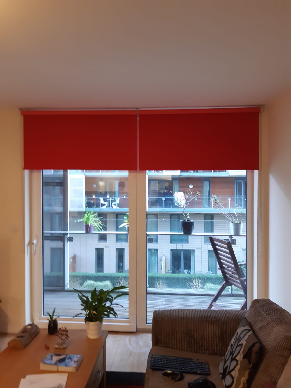 A living room with a red blind on the window