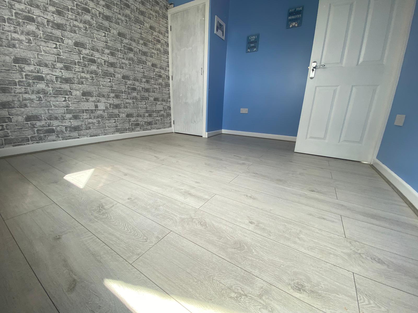 A room with blue walls and white doors and a wooden floor.
