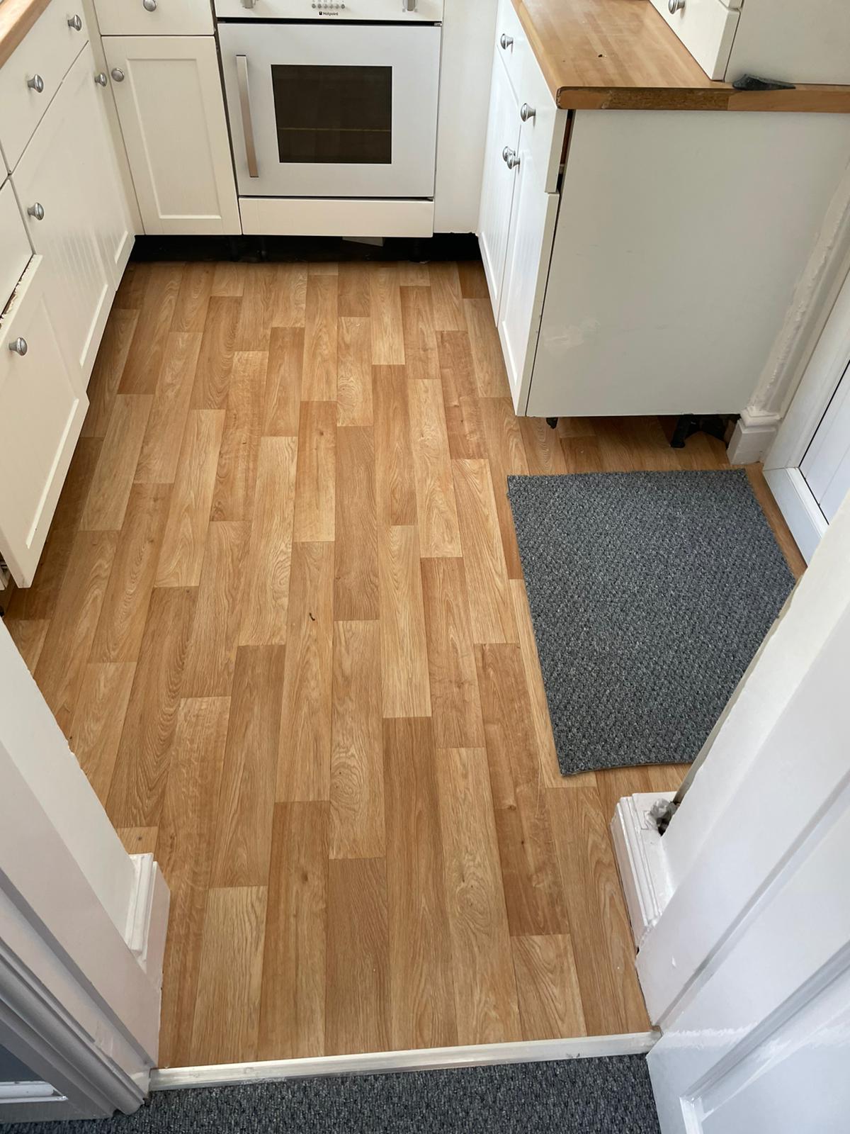 A kitchen with a wooden floor and white cabinets.
