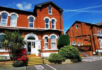 A large red brick building with a handicapped parking spot in front of it