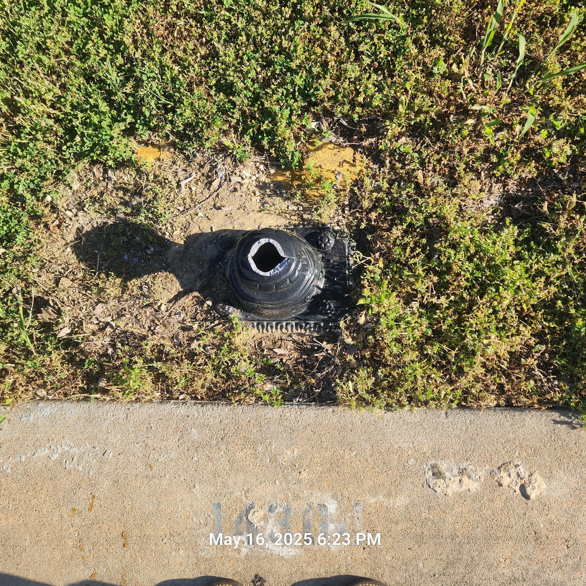 A fire hydrant is sitting in the grass next to a sidewalk.
