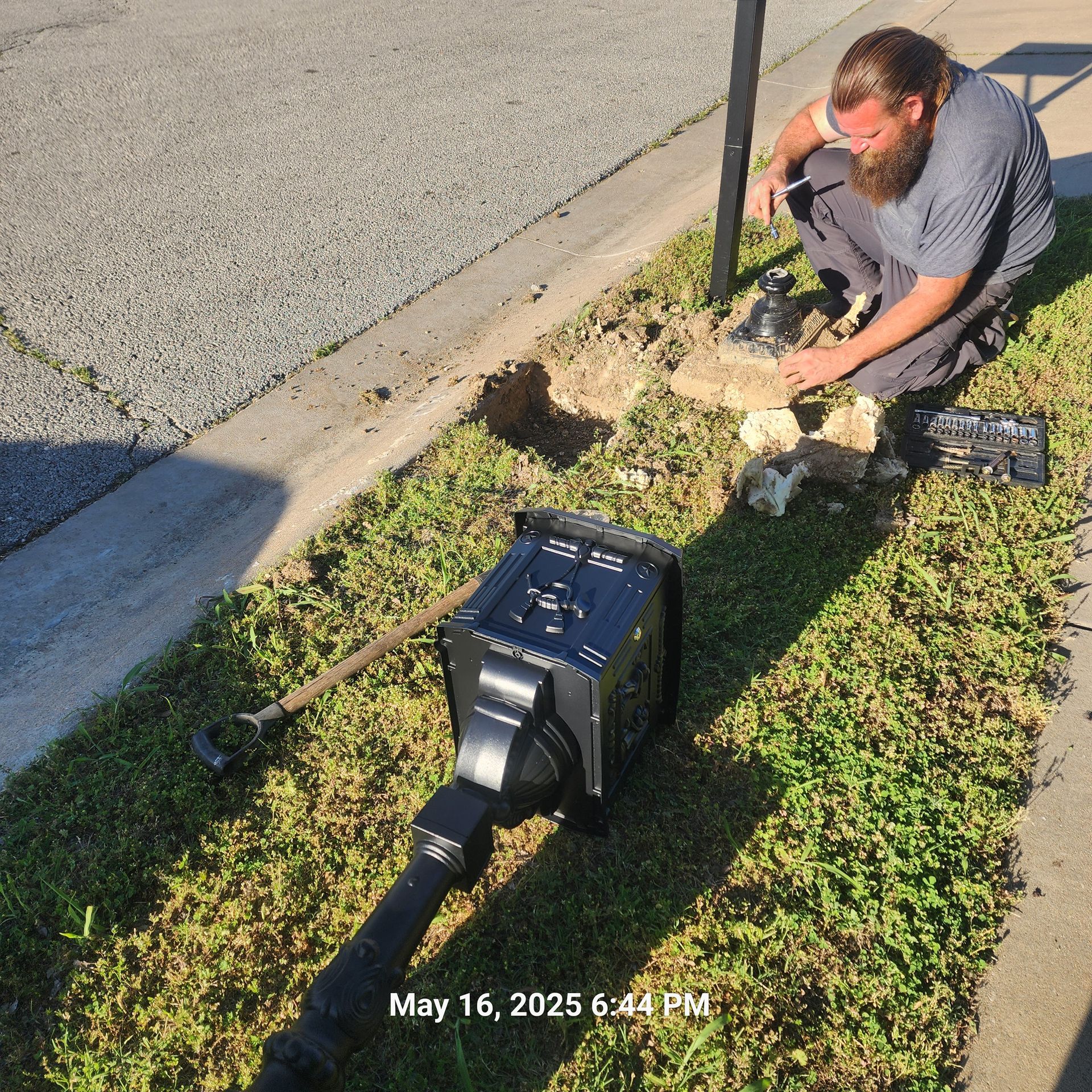 A man is working on a street light on may 16th at 6:44 pm