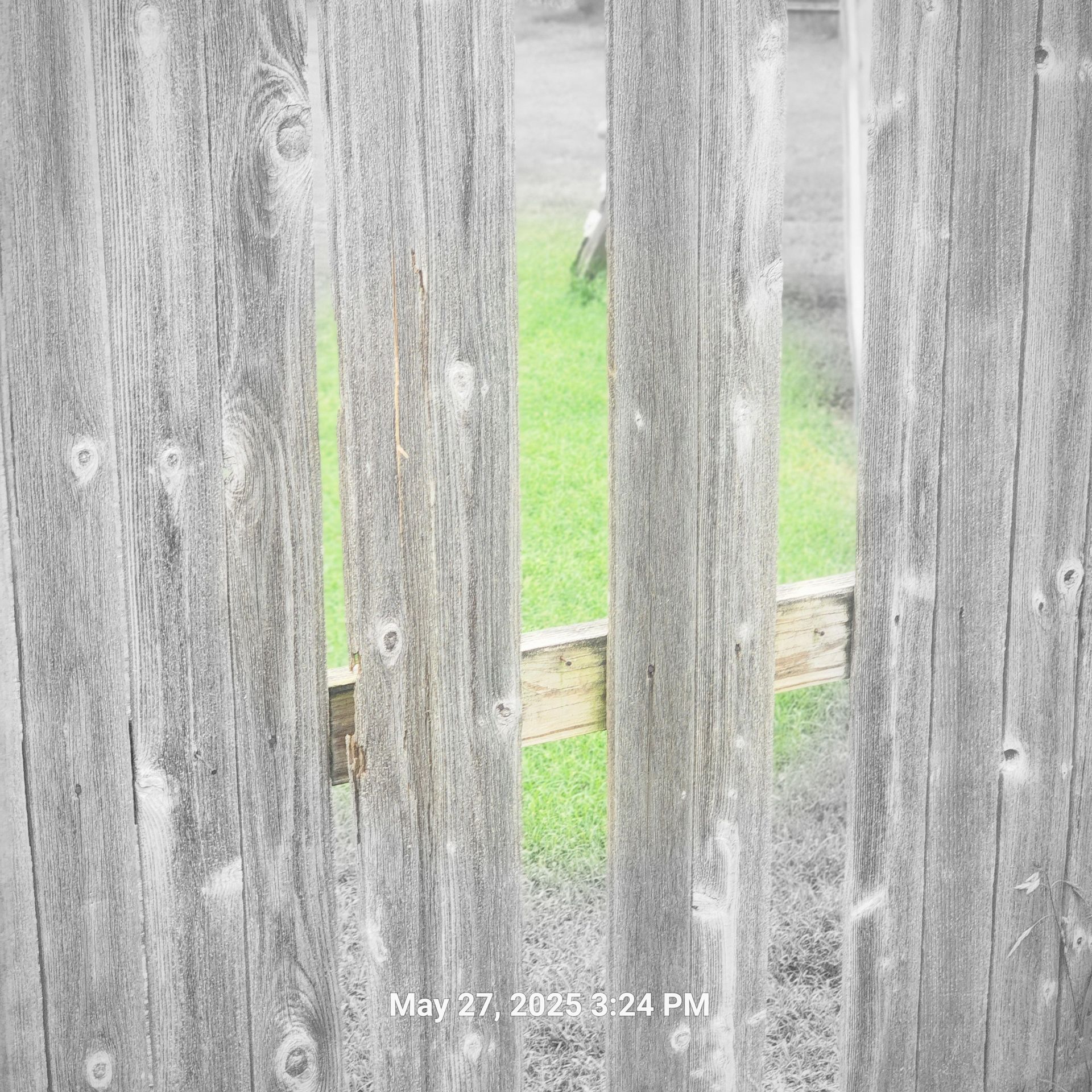 A picture of a wooden fence taken on may 27th at 3:24 pm