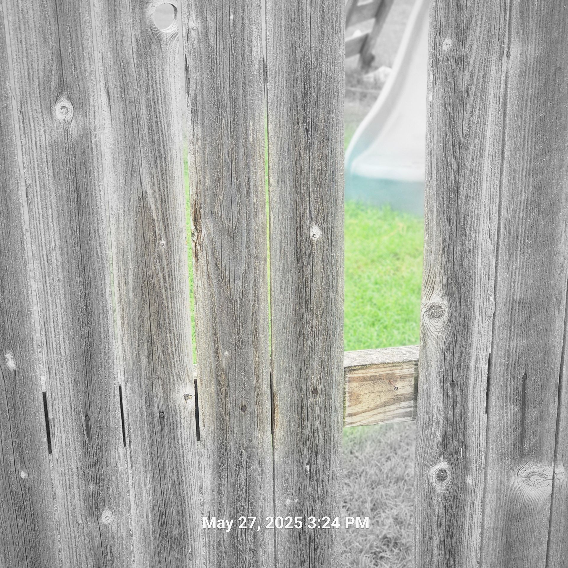 A picture of a wooden fence taken on may 27th at 3:24 pm