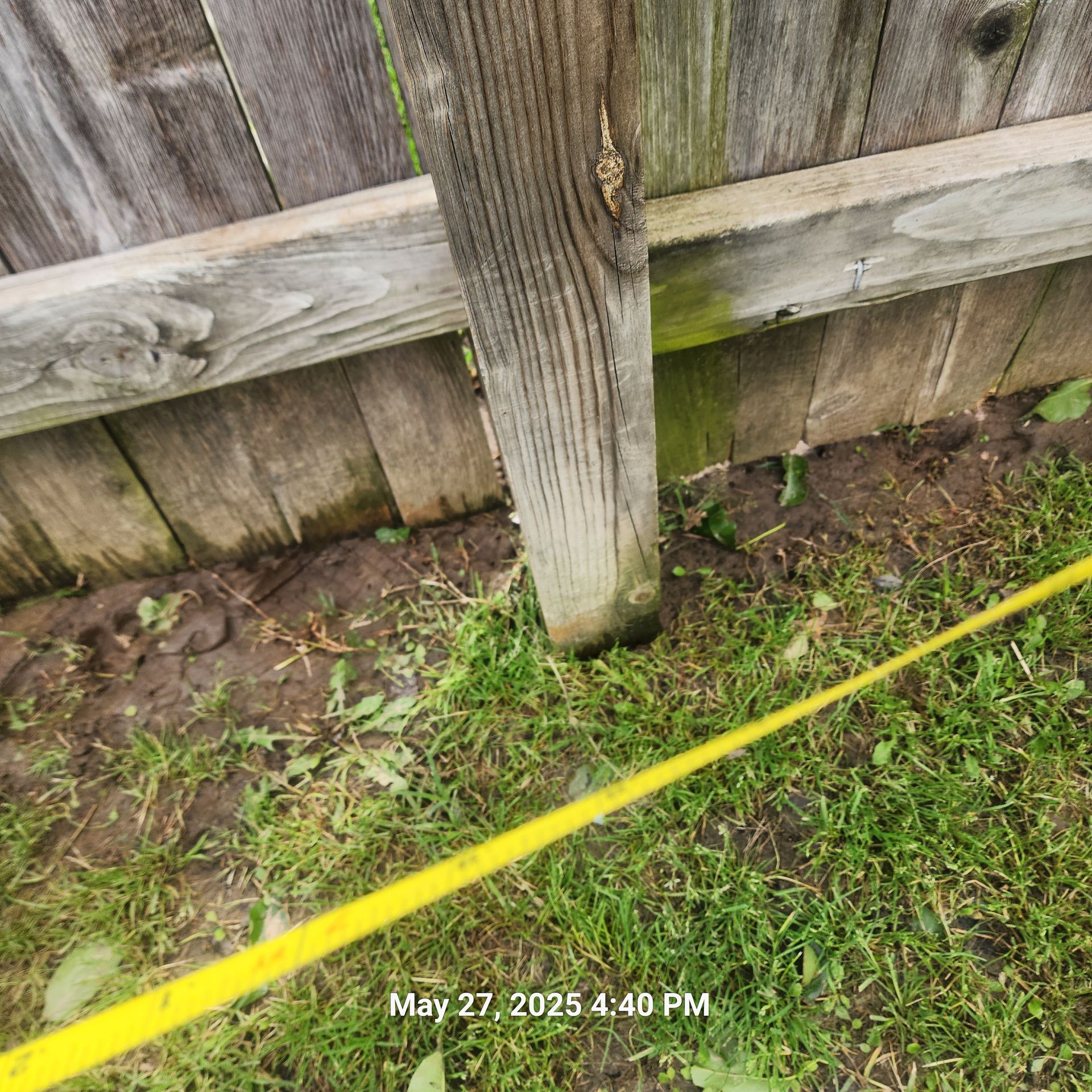 A wooden fence with a yellow tape around it.