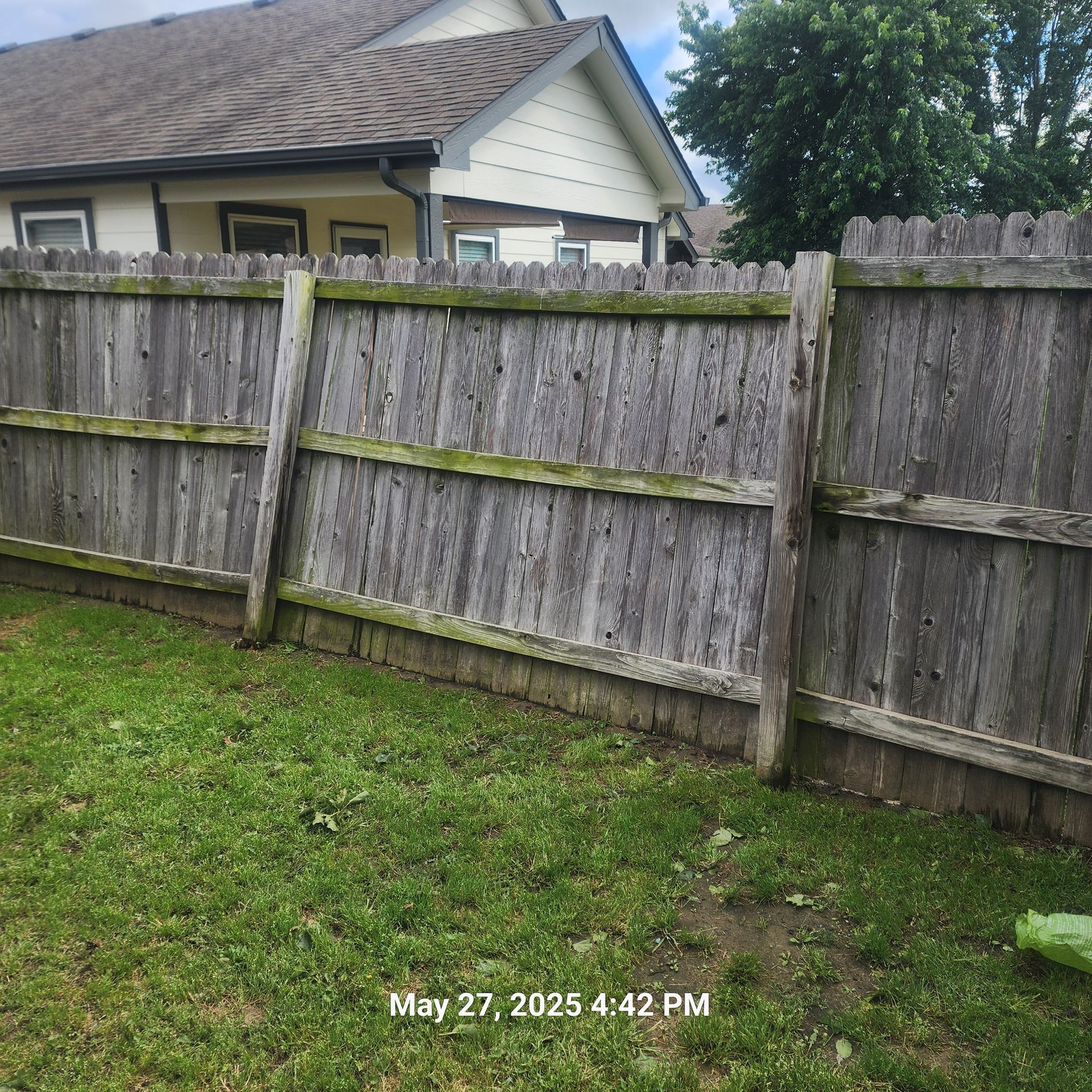A picture of a wooden fence taken on may 27th at 4:42 pm