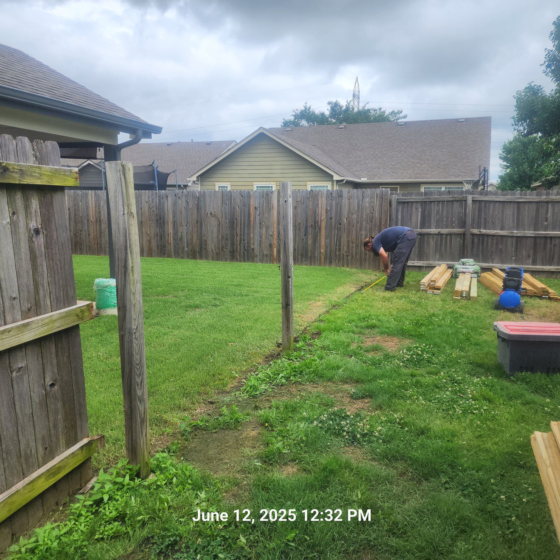 A man is working in a backyard on june 12 at 12:32 pm