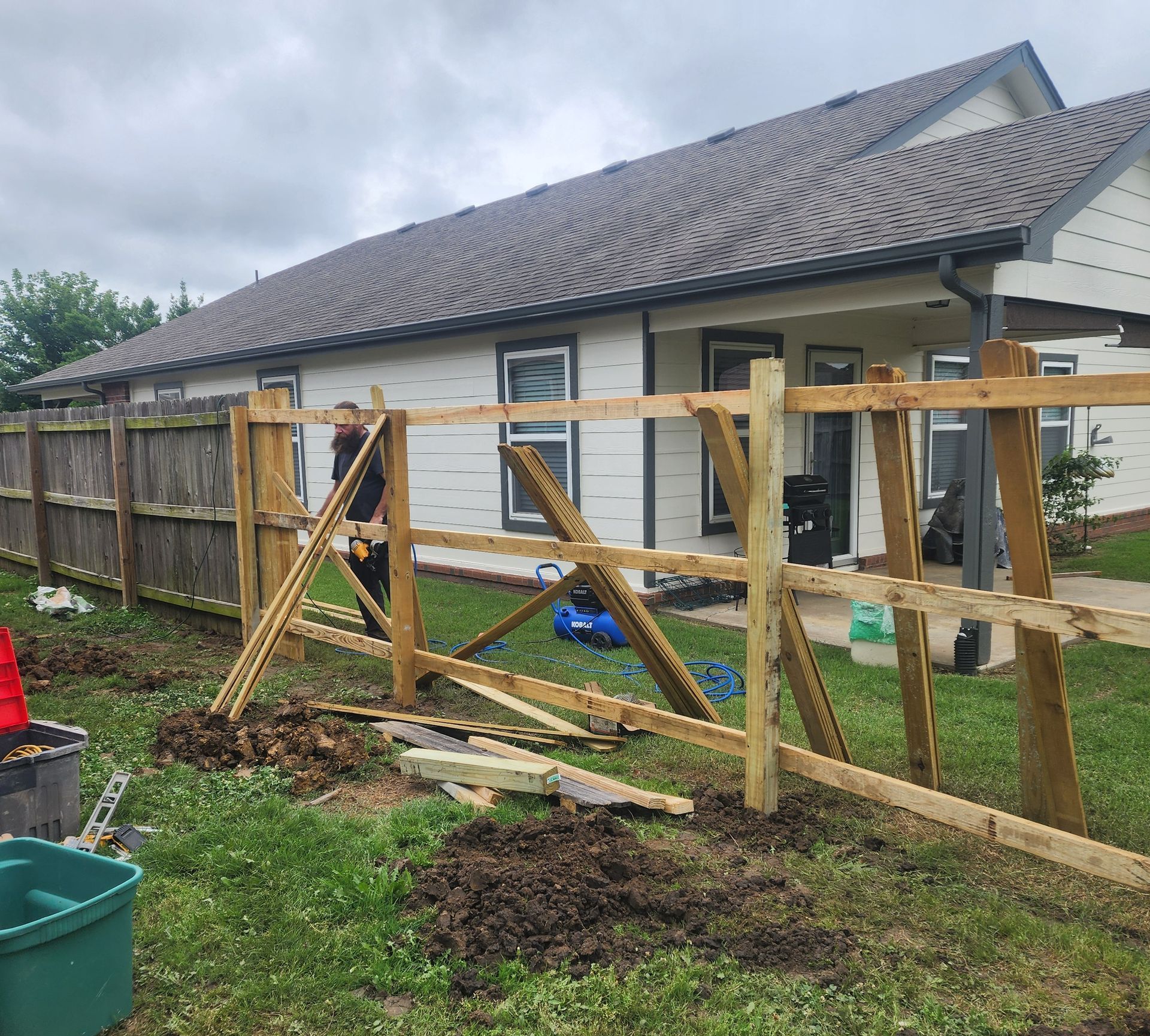 A wooden fence is being built in front of a house.