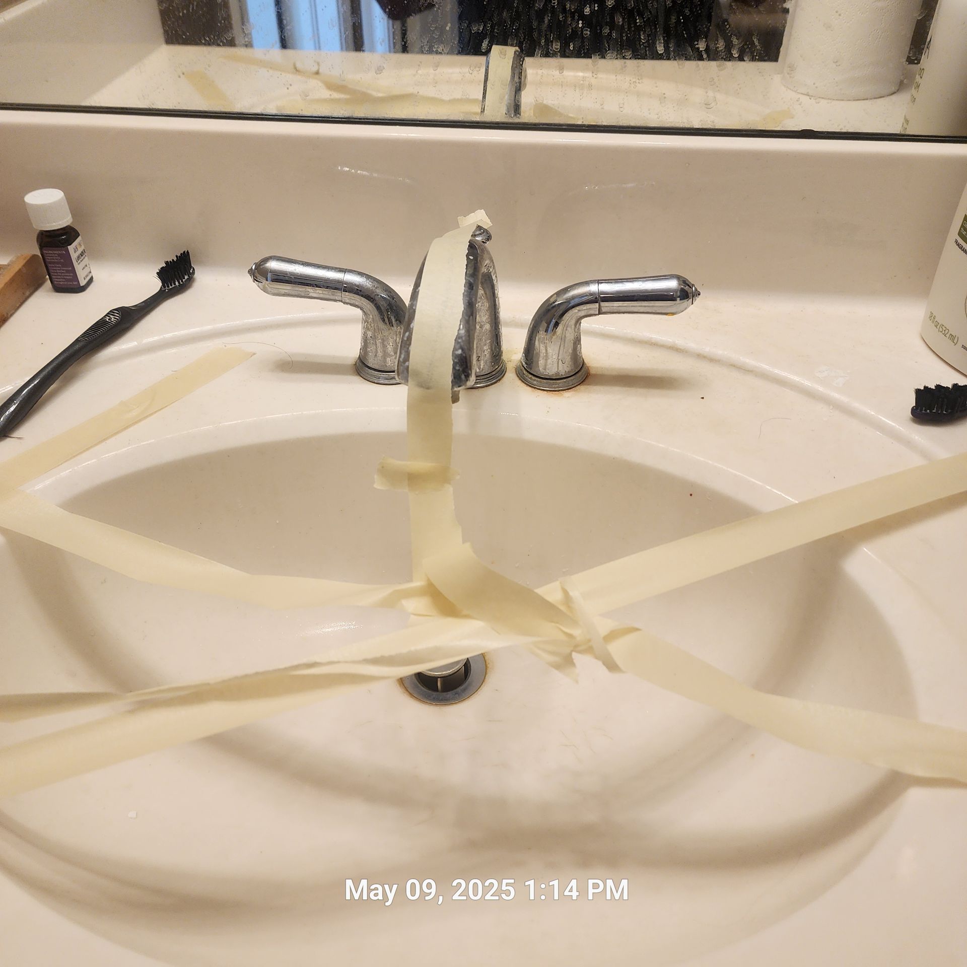 A bathroom sink with tape around it and the date may 09 2025