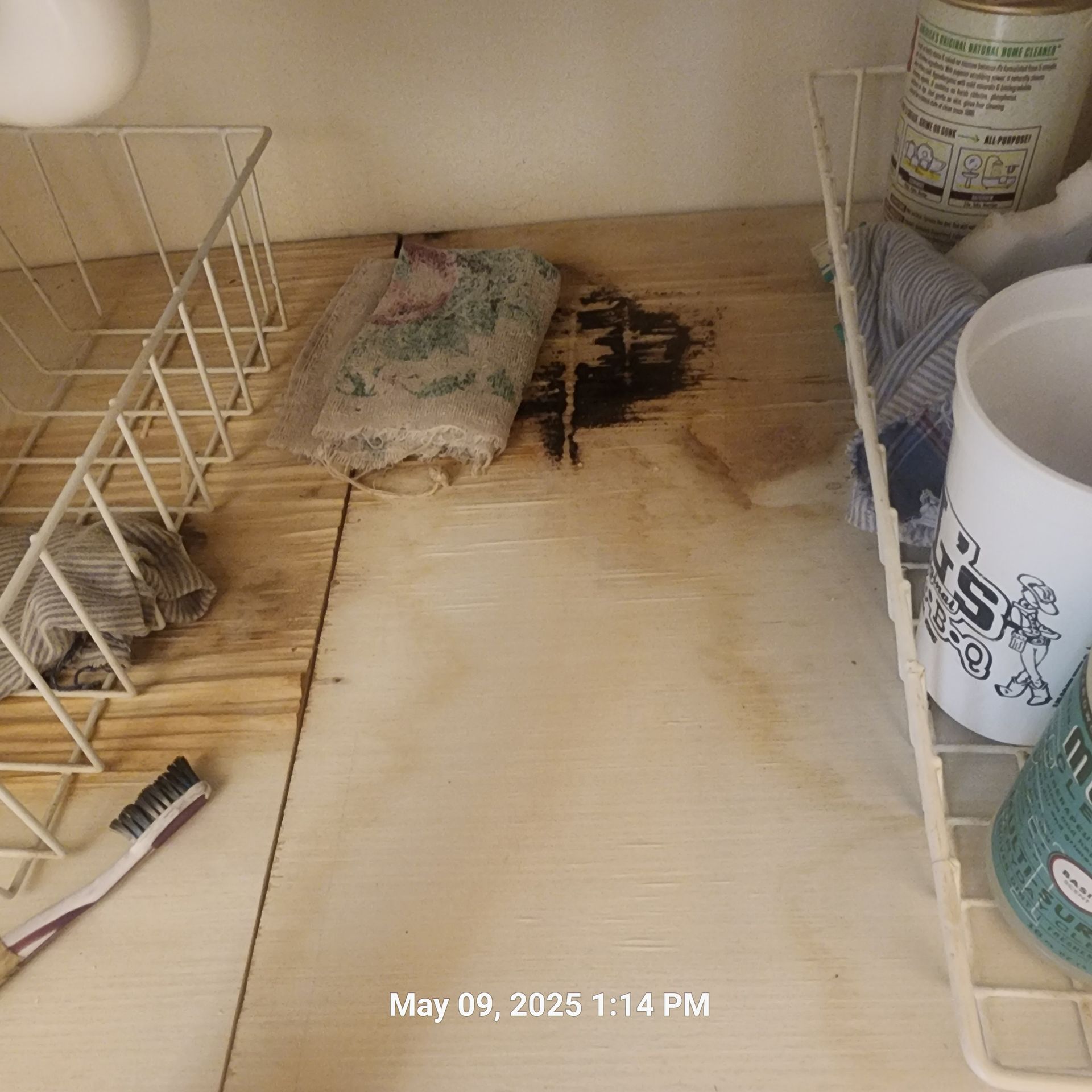 A shelf with a toothbrush and a mug on it