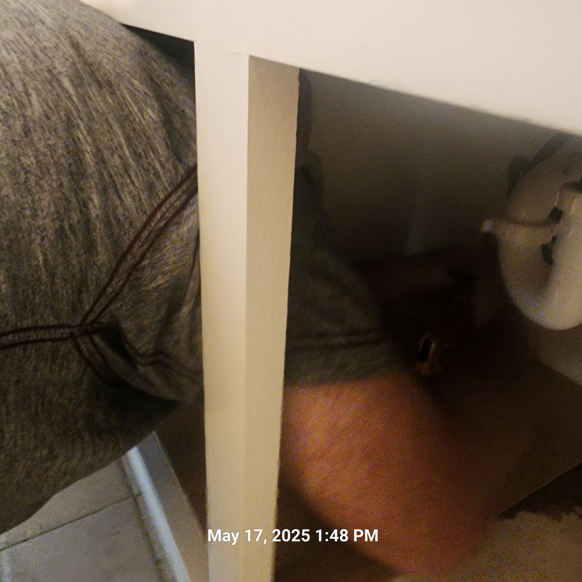 A man laying under a table on may 17th at 1:48 pm