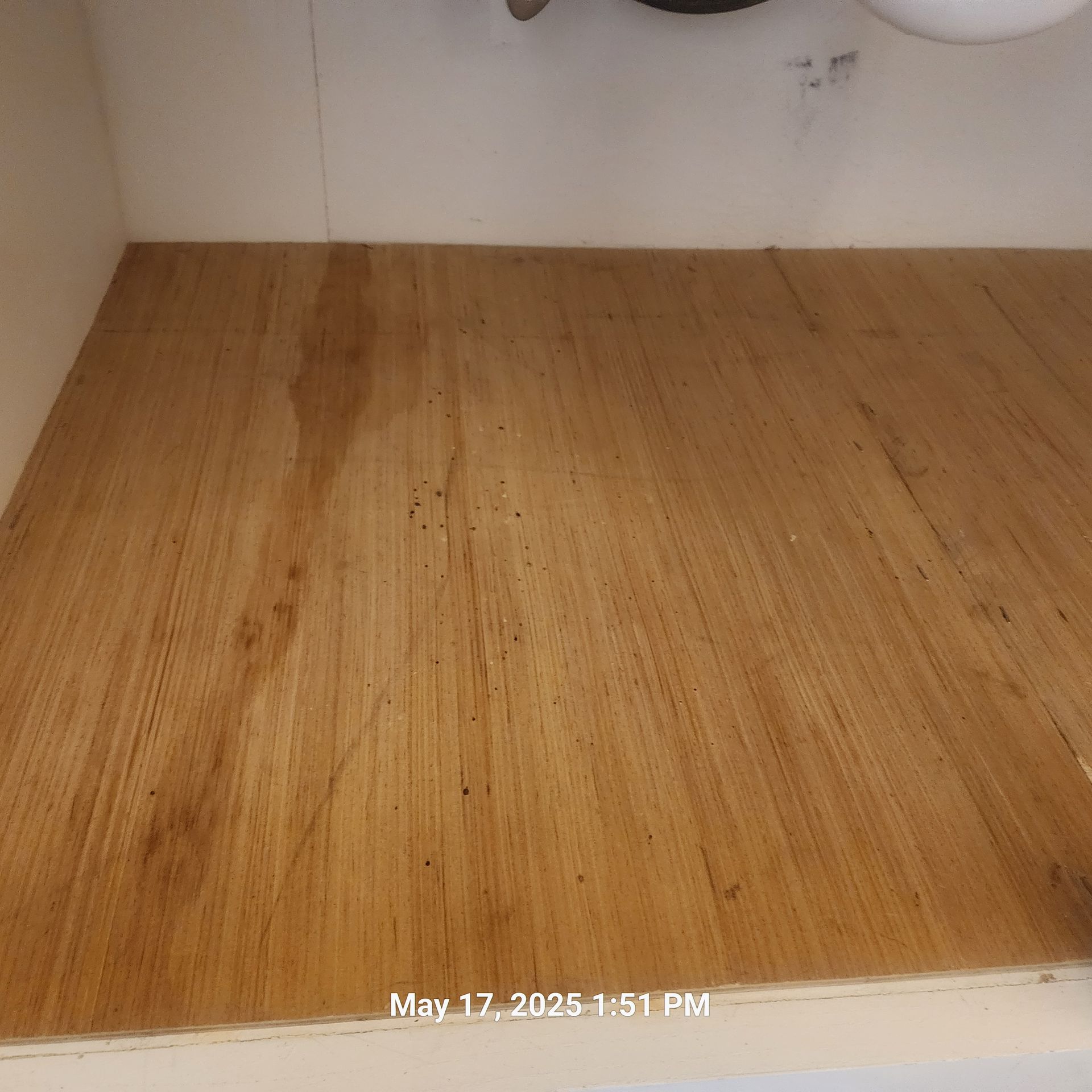 A wooden floor in a bathroom with a sink underneath it.