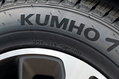 A close up of a kumho tire on a wheel