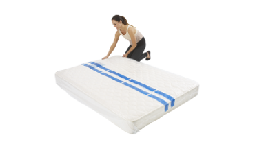 A Woman is Kneeling Over a White Mattress With Blue Stripes on It — Huskisson Self Storage in Huskisson, NSW