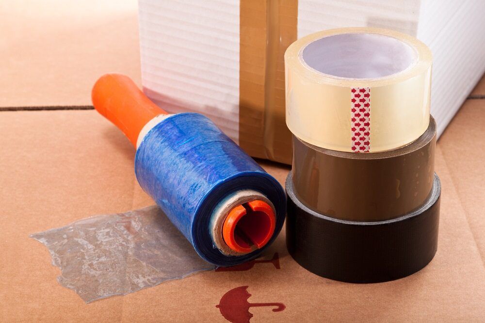 Three Rolls of Tape Are Stacked on Top of Each Other on a Cardboard Box — Huskisson Self Storage in Huskisson, NSW