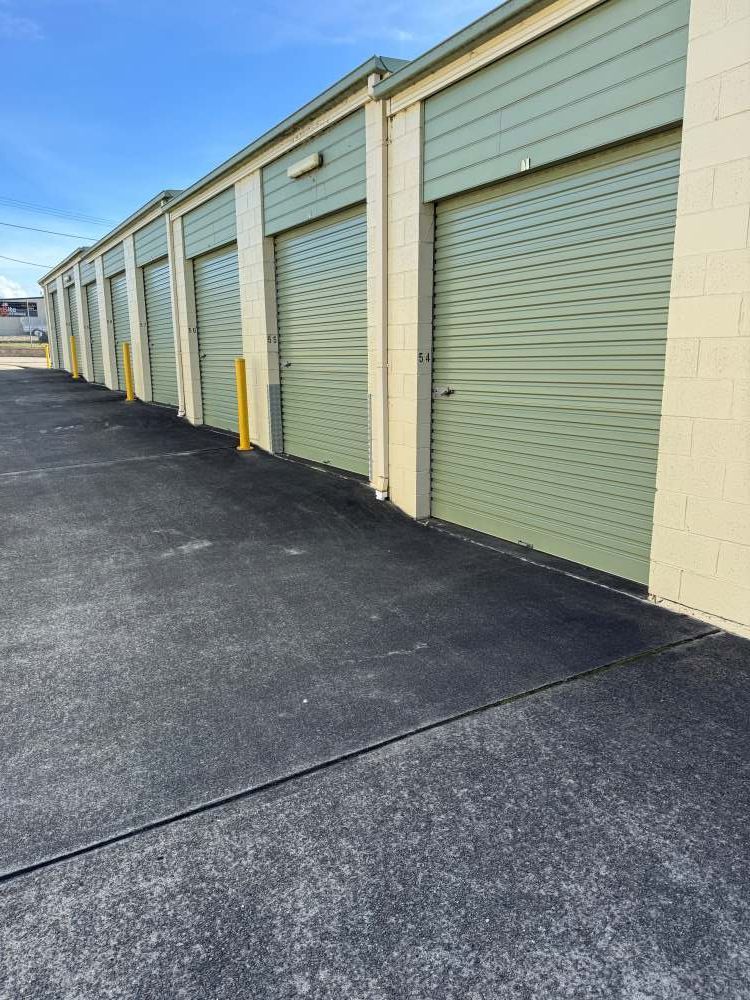A Row of Green Garage Doors Are Lined Up in a Parking Lot — Huskisson Self Storage in Huskisson, NSW