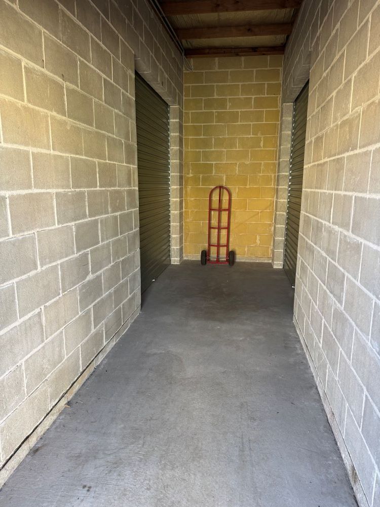 A Brick Hallway With a Hand Truck in the Middle of It — Huskisson Self Storage in Vincentia, NSW