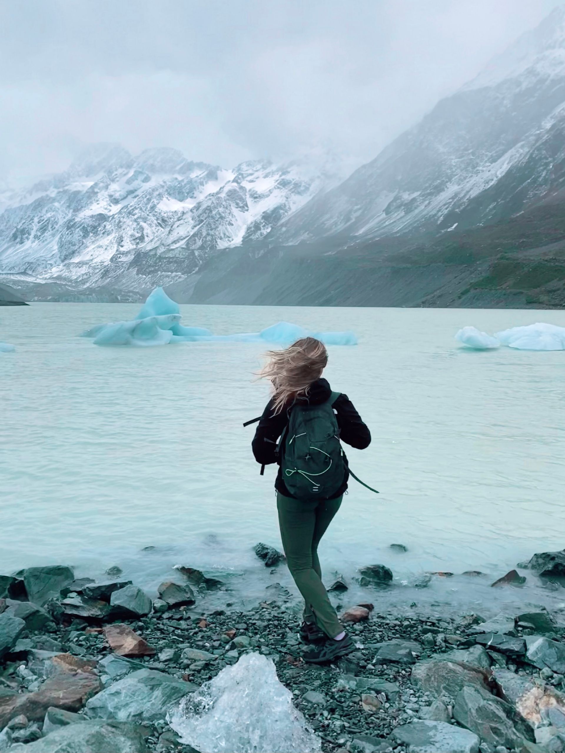 A family is standing on a pier overlooking the ocean at sunset.