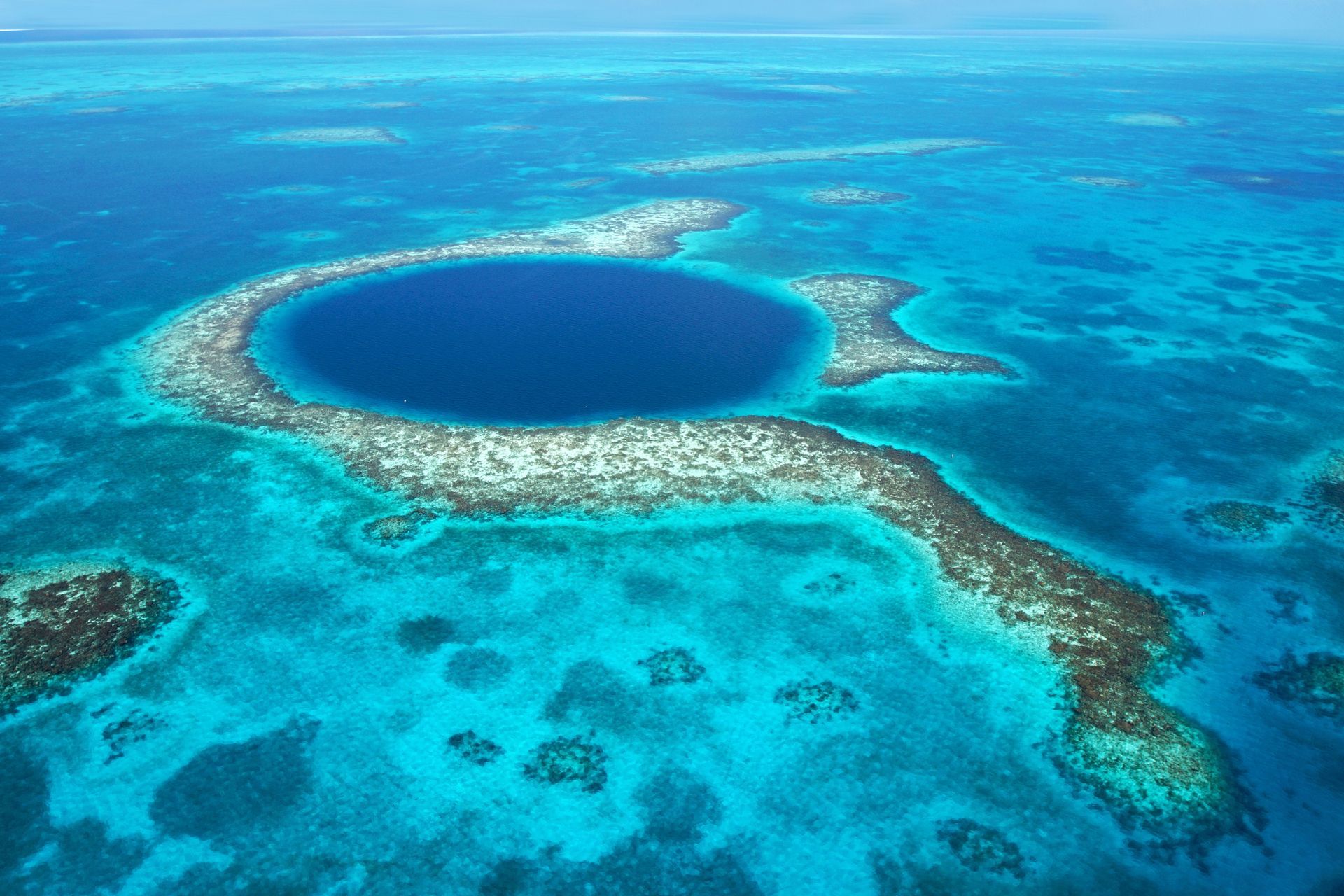 An aerial view of a belize hole in the middle of the ocean