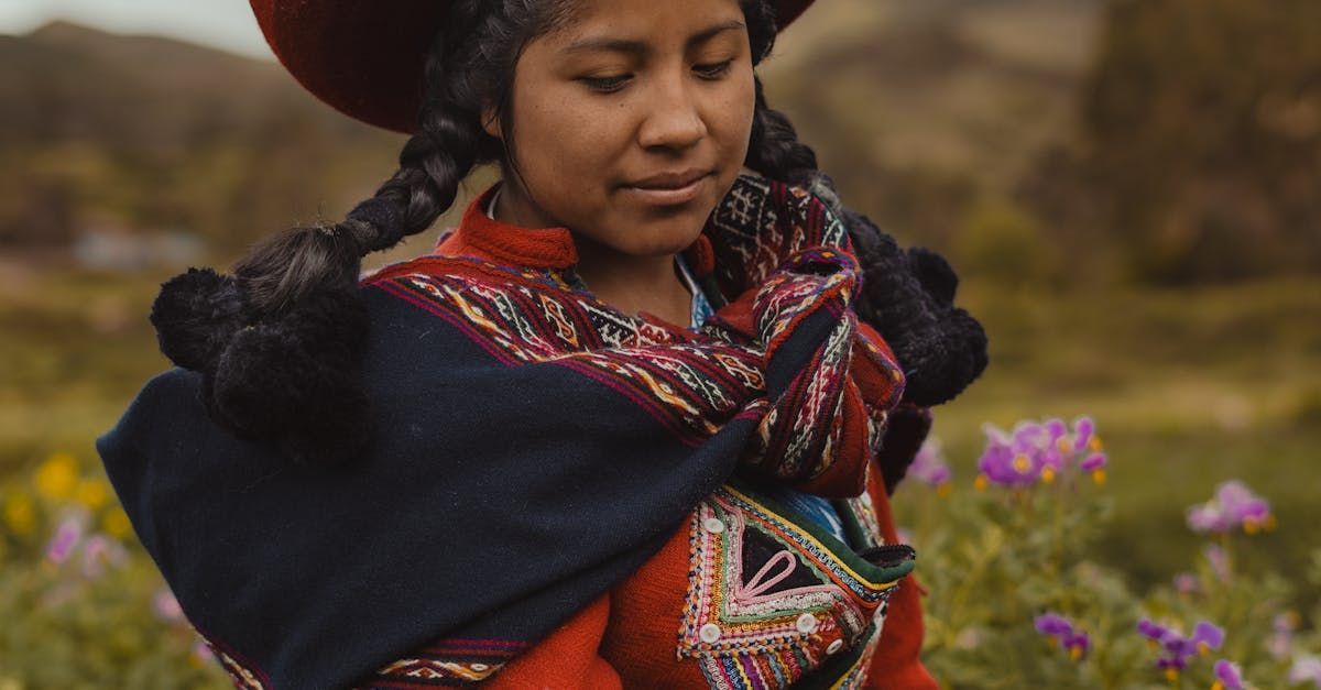 A woman in a red dress is standing in a field of flowers.