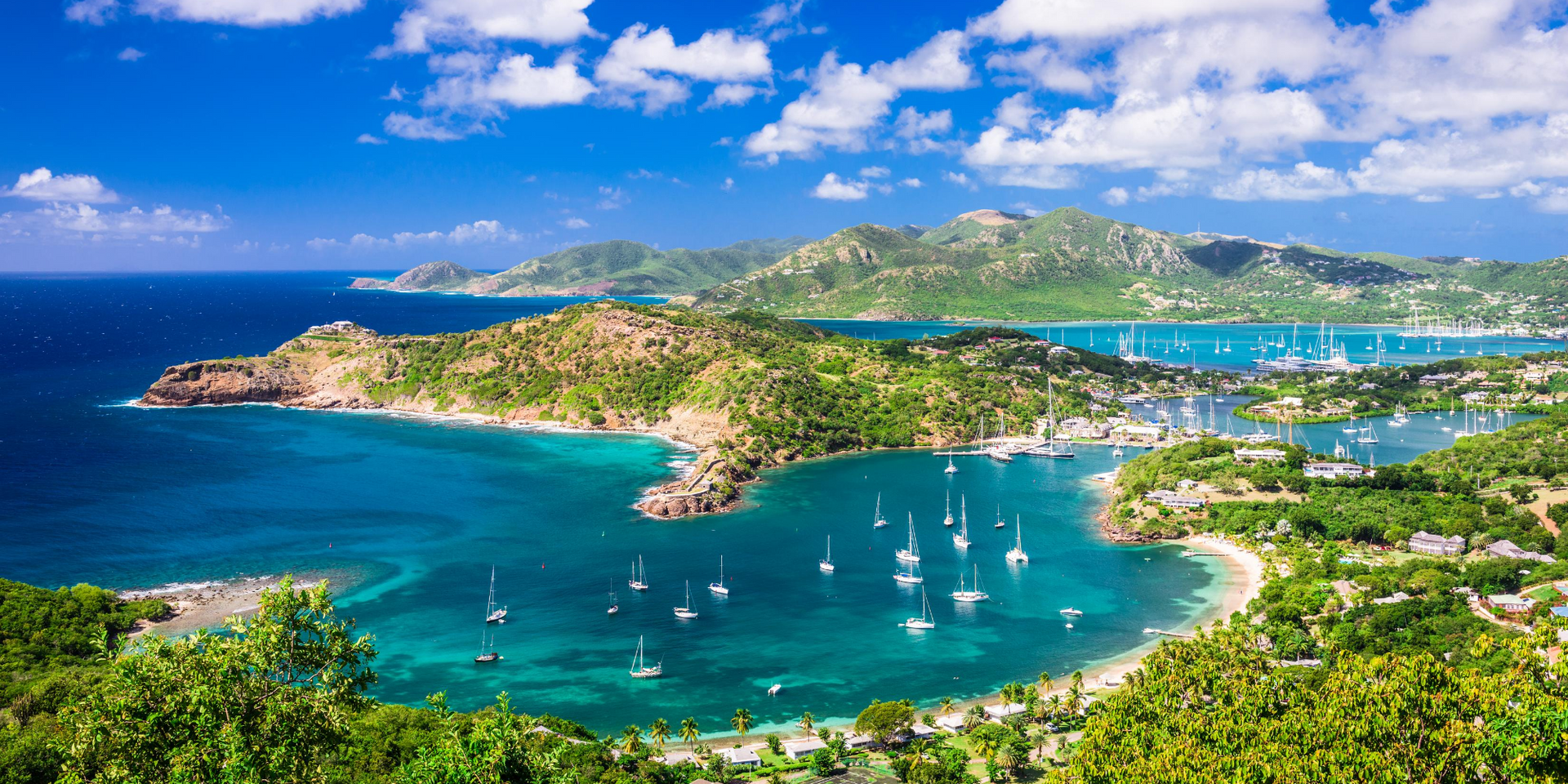 An aerial view of a tropical island with boats in the water.