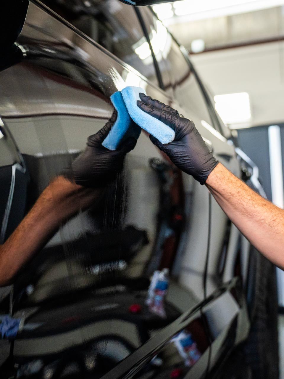 A person is washing a car wheel with foam