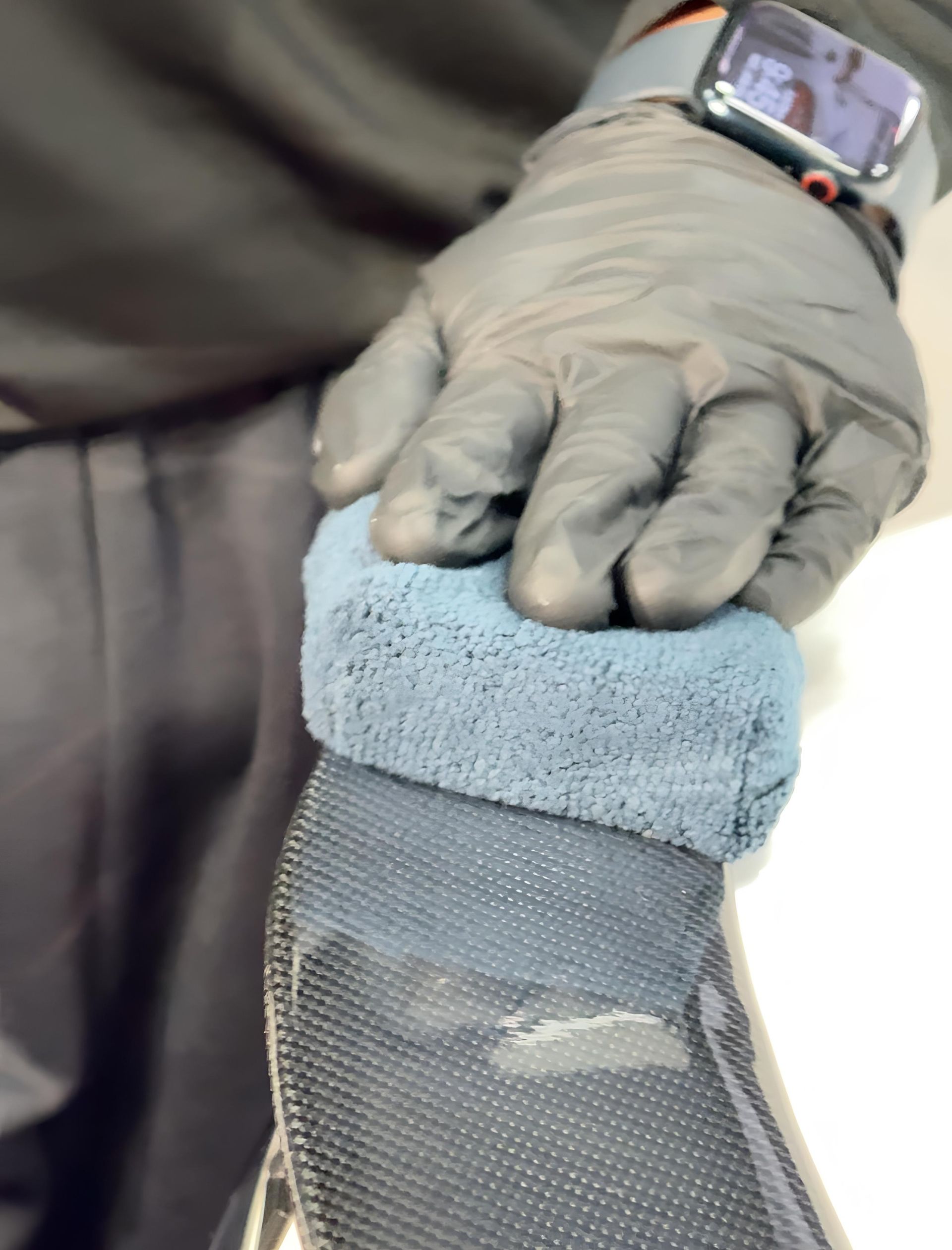 A person is washing a car wheel with foam