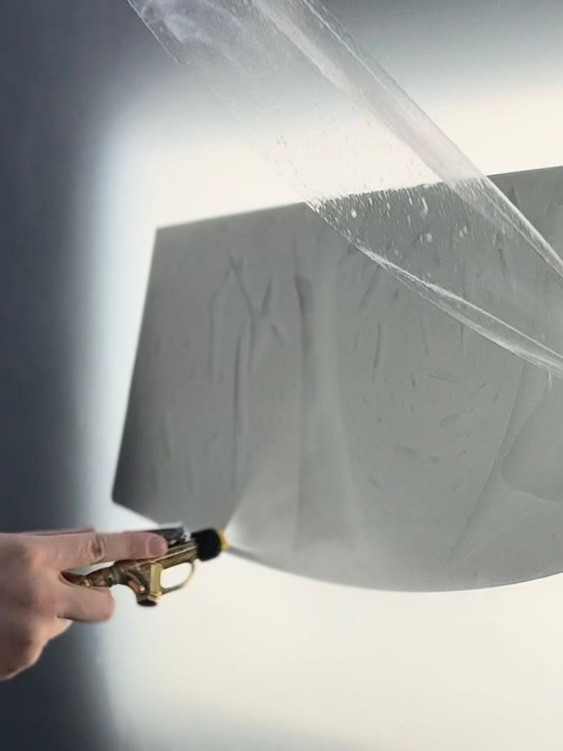A person is applying tinted glass to a car windshield.