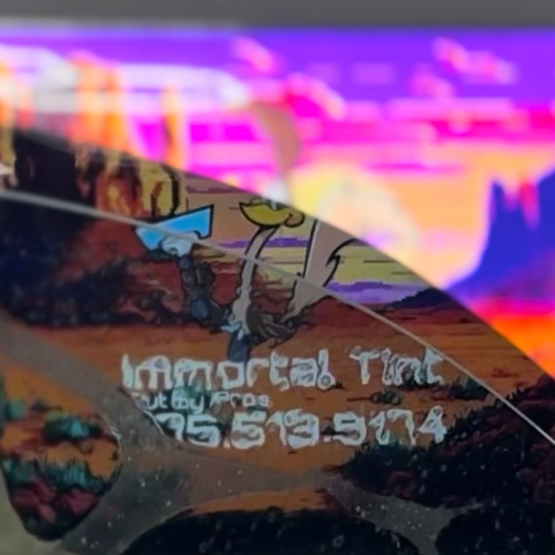 A person is cleaning a blue car with an orange towel