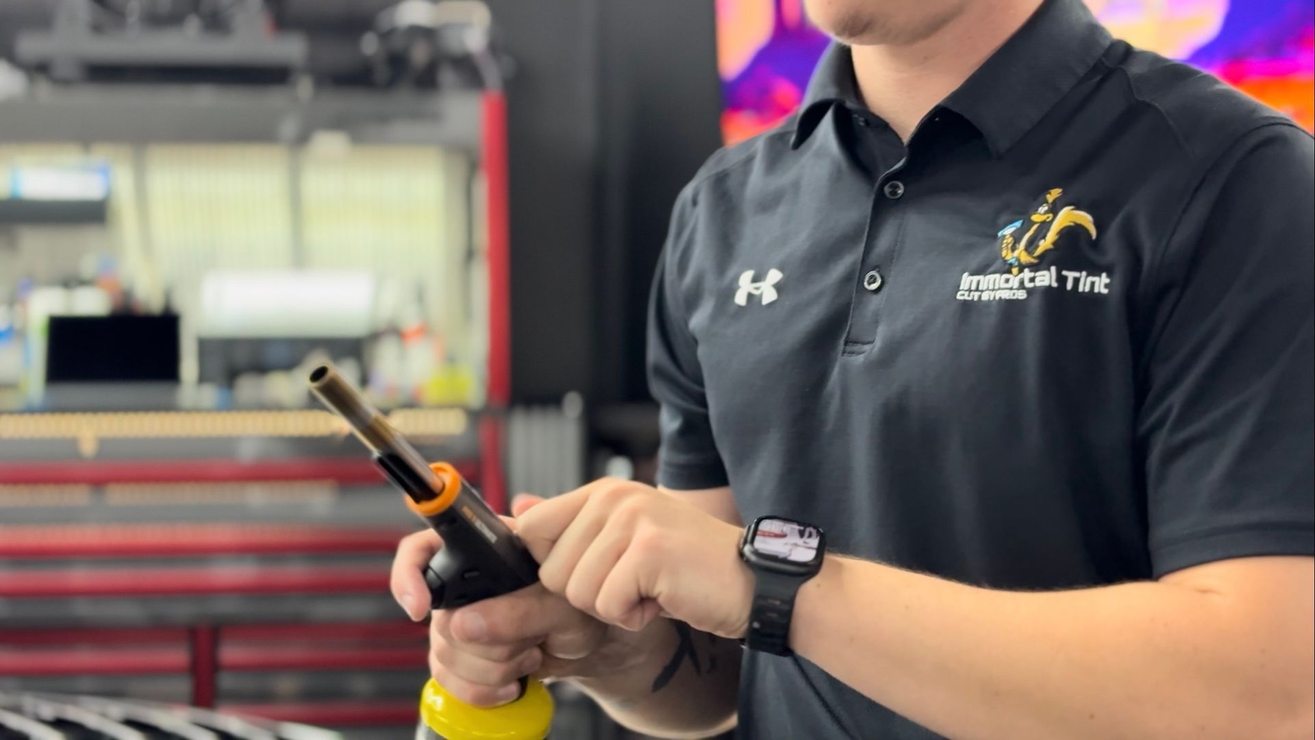 A man is holding a piece of glass with a picture of a cat on it