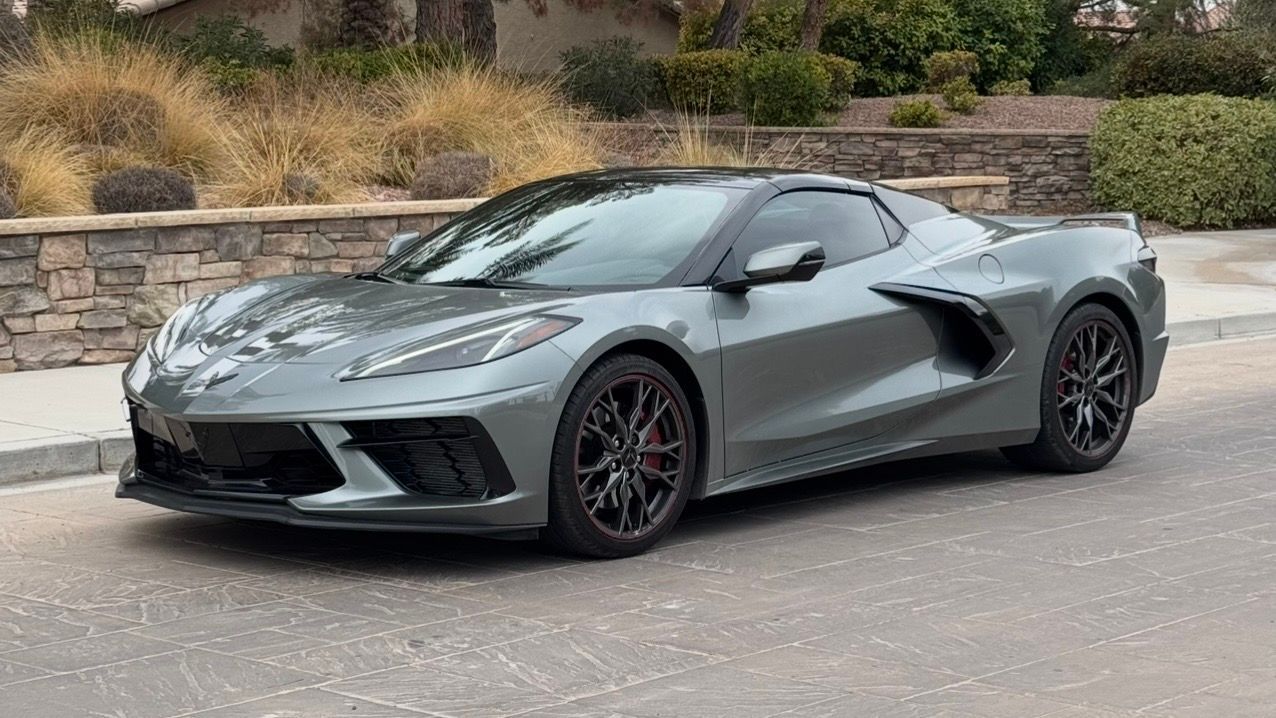 A gray corvette is parked on the side of the road.