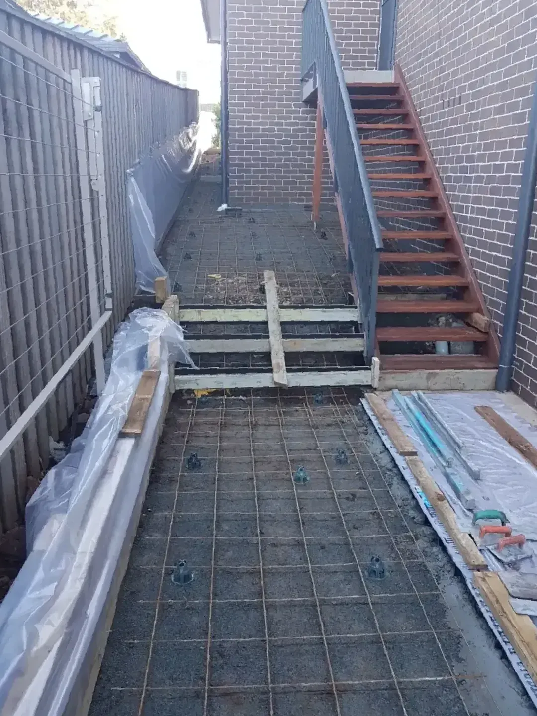 A Staircase Is Being Built In The Backyard Of A House — DCK Concreting In Lake Cathie, NSW