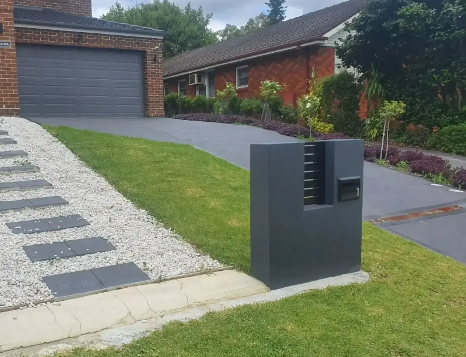 A House With A Driveway And A Mailbox In Front Of It — DCK Concreting In Lake Cathie, NSW