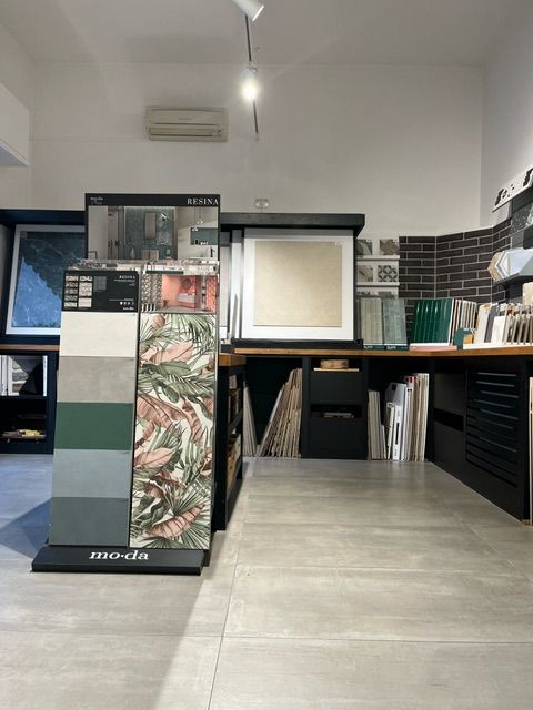 Interno dello showroom di piastrelle con pannelli espositivi che mostrano vari campioni di piastrelle.