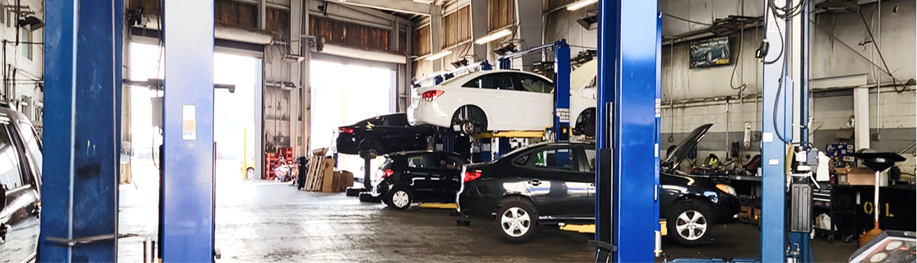 Auto repair shop with cars on lifts in a large garage