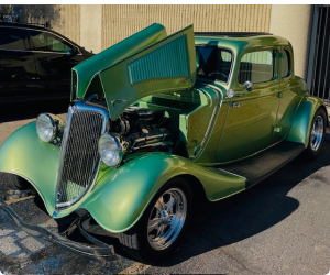 Green classic car with open hood, parked outdoors. | Arizona Engine Rebuilding