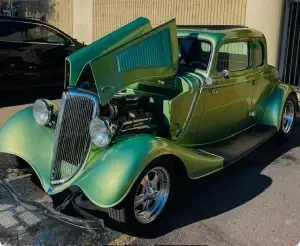 Green classic car with open hood, parked outdoors. | Arizona Engine Rebuilding