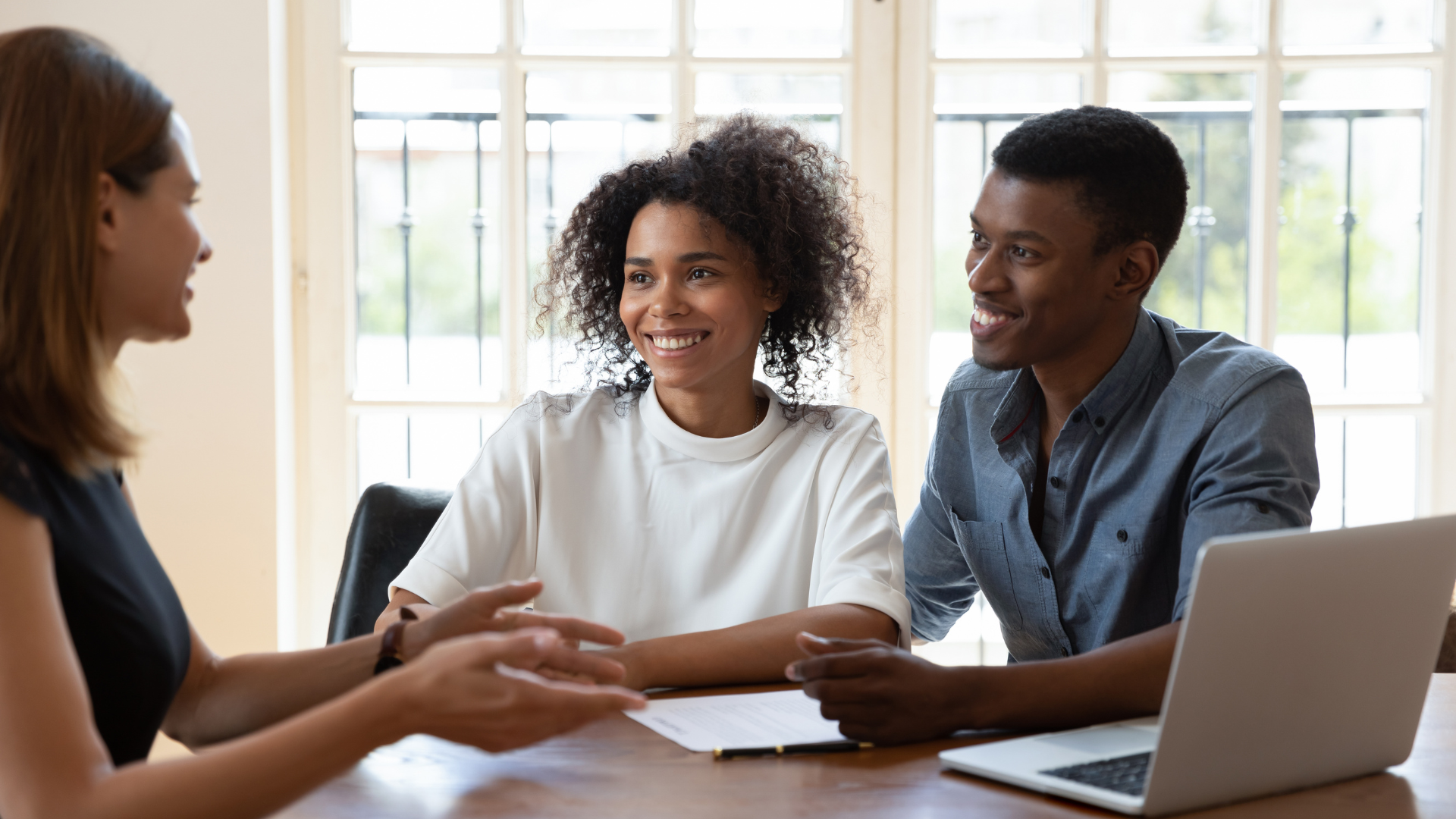 A man and a woman are sitting at a table signing a document.