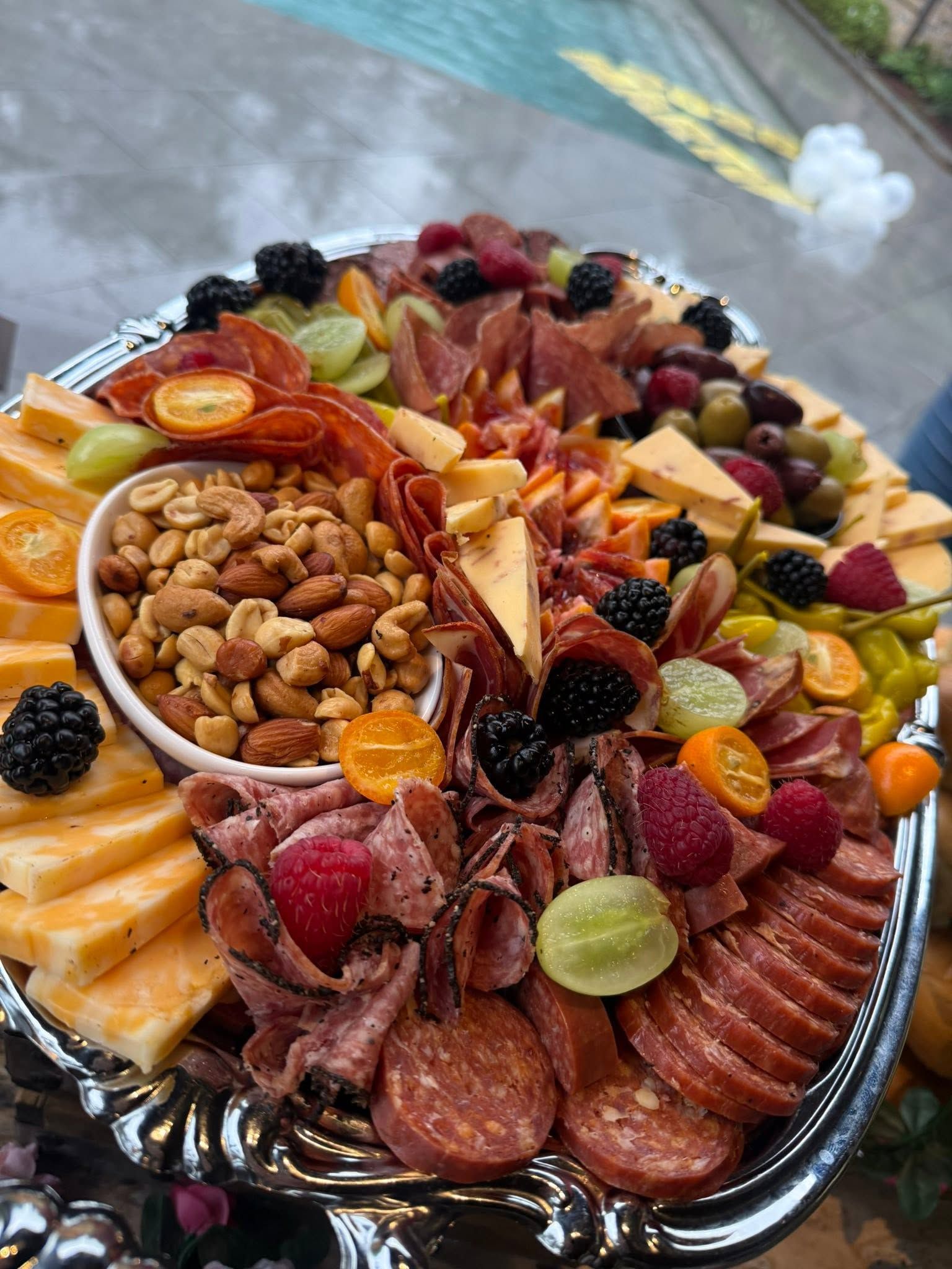 Fruit and cheese charcuterie platter with nuts and cured meats on a serving tray