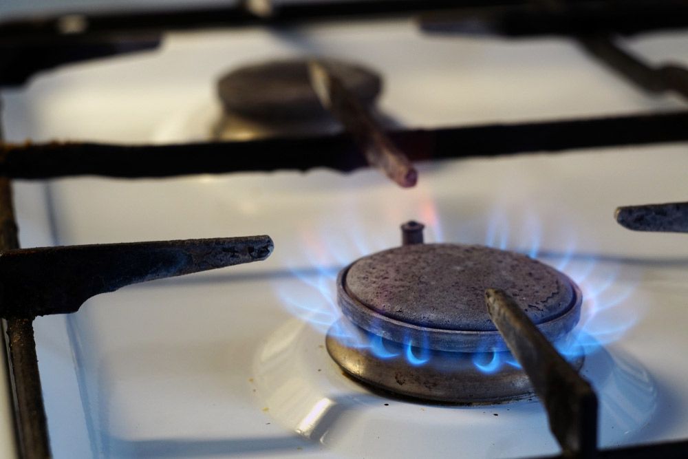 A Close Up of a Gas Stove With a Blue Flame Coming Out of It — Rock Plumbing & Gasfitting In Airlie Beach, QLD