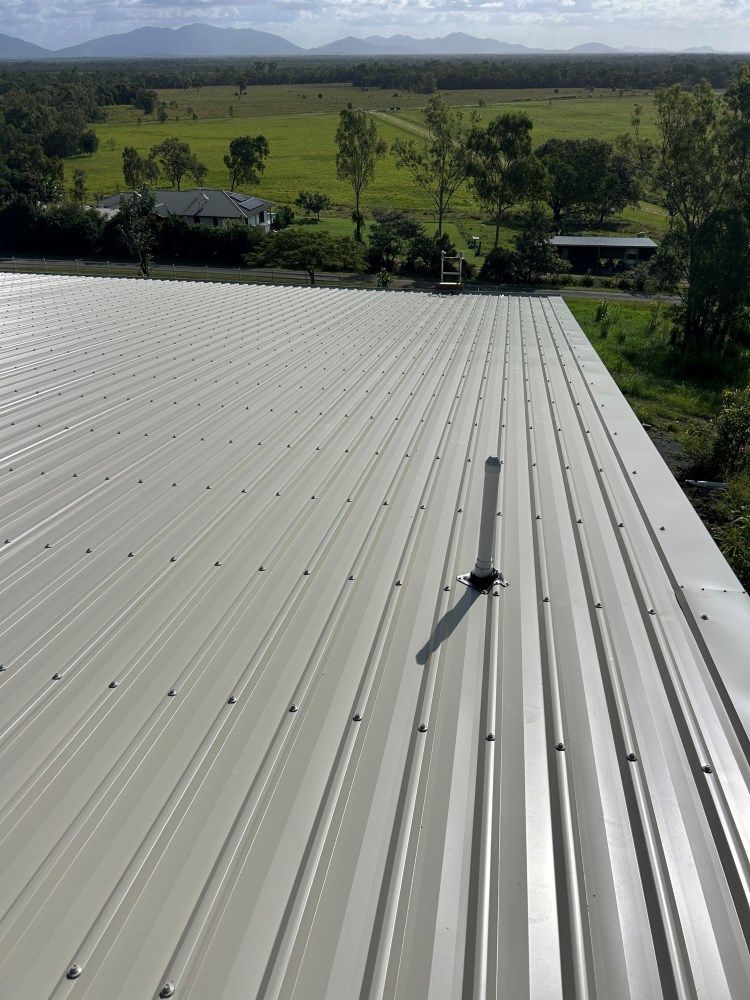 A white metal roof with a view of a field — Rock Plumbing & Gasfitting In Cannonvale, QLD