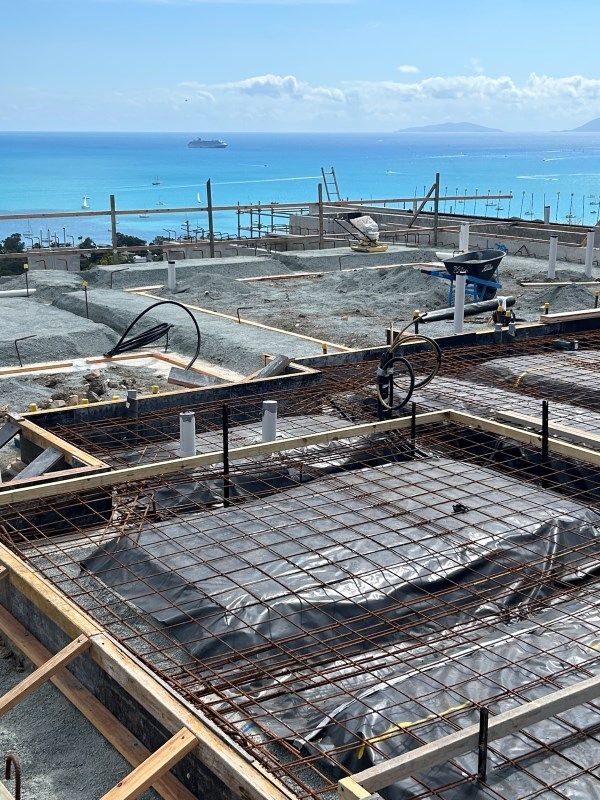 A Construction Site With A View Of The Ocean In The Background — Rock Plumbing & Gasfitting In Cannonvale, QLD