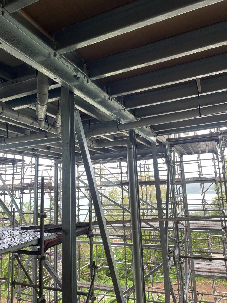 A Large Building Under Construction With A Lot Of Scaffolding — Rock Plumbing & Gasfitting In Cannonvale, QLD