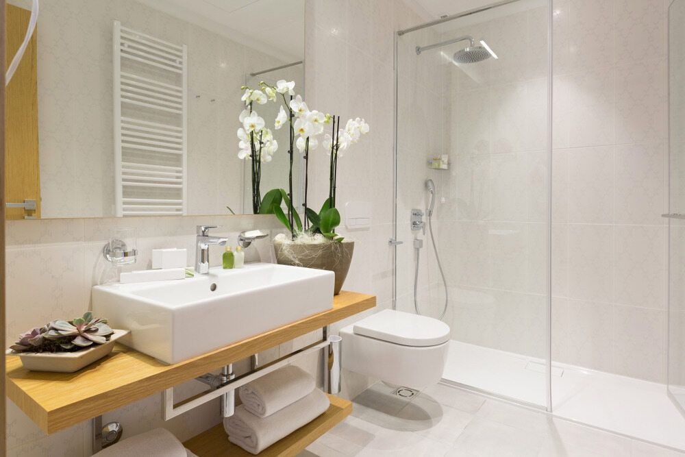 A Bathroom With a Sink, Toilet, Shower and Mirror — Rock Plumbing & Gasfitting In Cannonvale, QLD