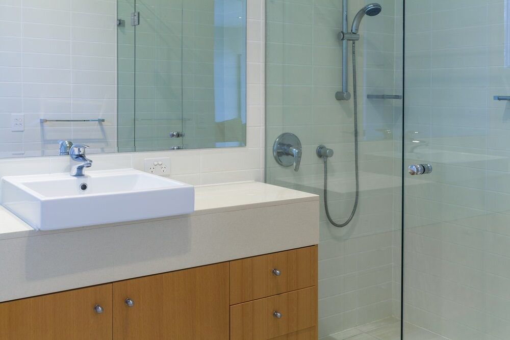 A Bathroom With a Sink, Shower and Mirror — Rock Plumbing & Gasfitting In Proserpine, QLD