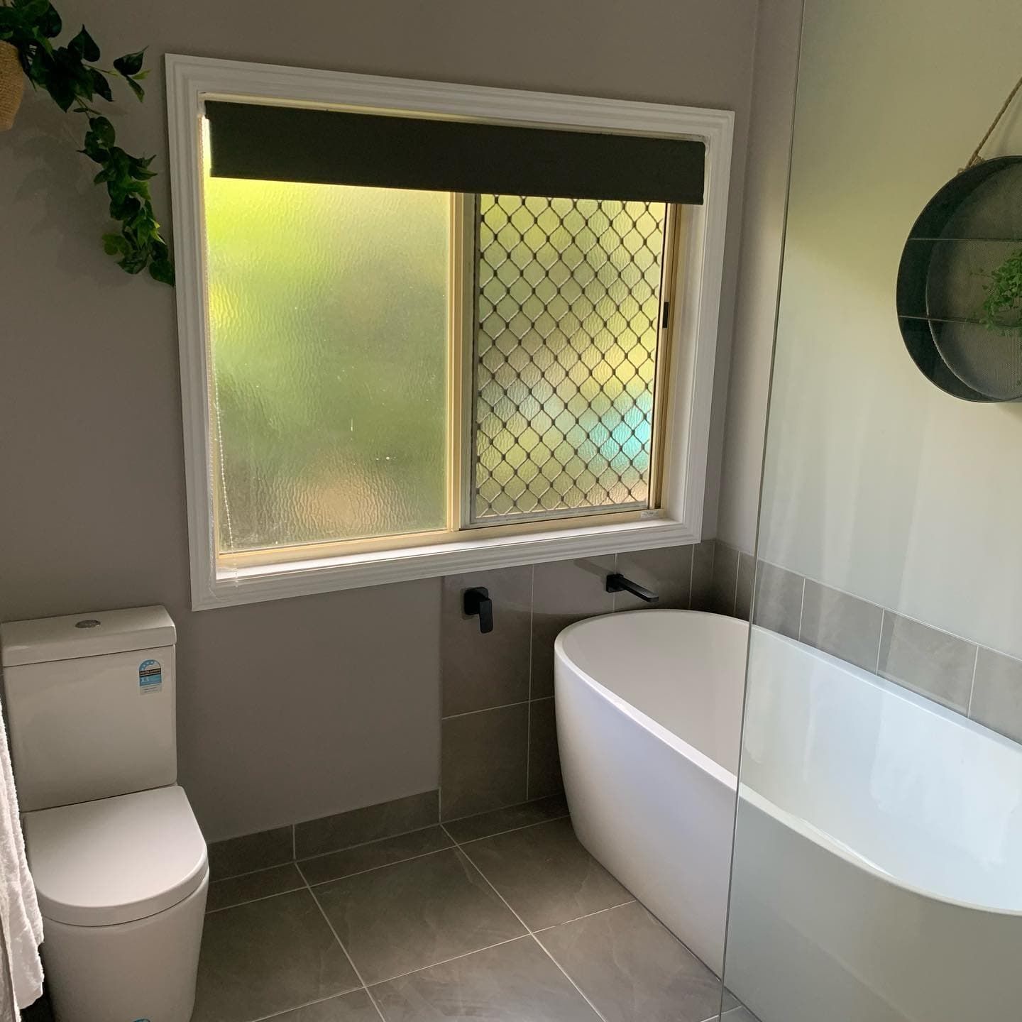 A Bathroom With a Toilet , Tub , and Window — Rock Plumbing & Gasfitting In Cannonvale, QLD